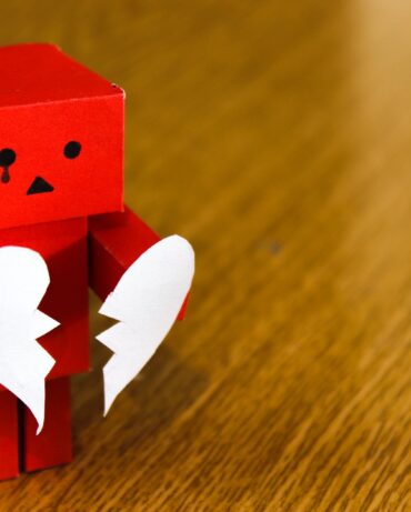 cardboard robot holding broken heart